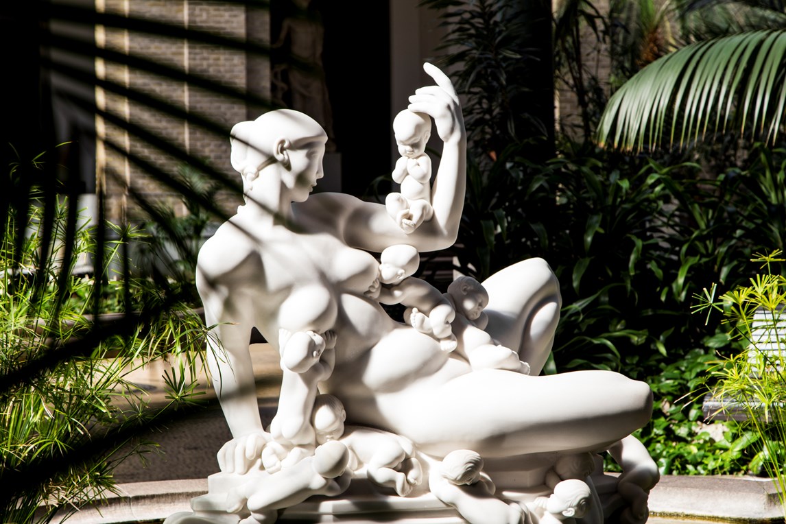 Sculpture of a nude woman with multiple babies, including breastfeeding, at New Carlsberg Glyptotek.