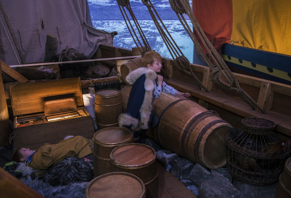 Young visitor interacting with a Viking ship display at Roskilde museum.