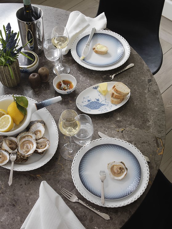 Elegant serving of oysters with bread and butter, highlighting a refined dining experience.