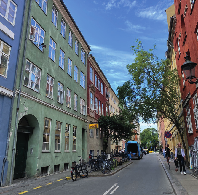 Narrow Copenhagen street lined with colorful apartment buildings, showcasing the city’s charming and varied architecture.
