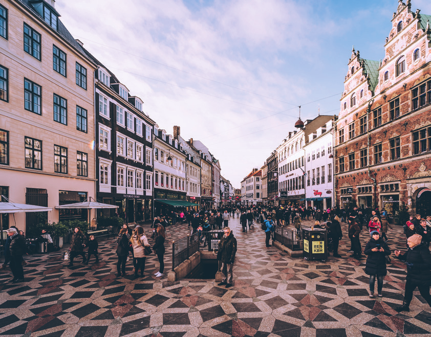 Crowded square on Strøget, Copenhagen, showing people shopping, walking, and enjoying the city’s central pedestrian area.