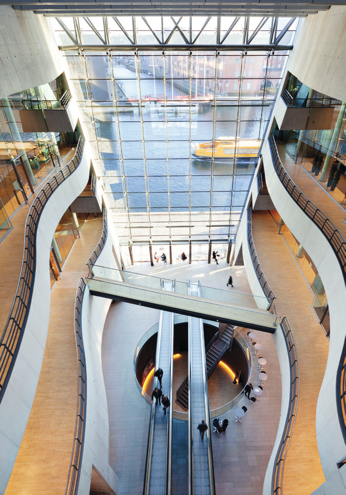 Interior of The Black Diamond library atrium, with view of the water through the glass facade.