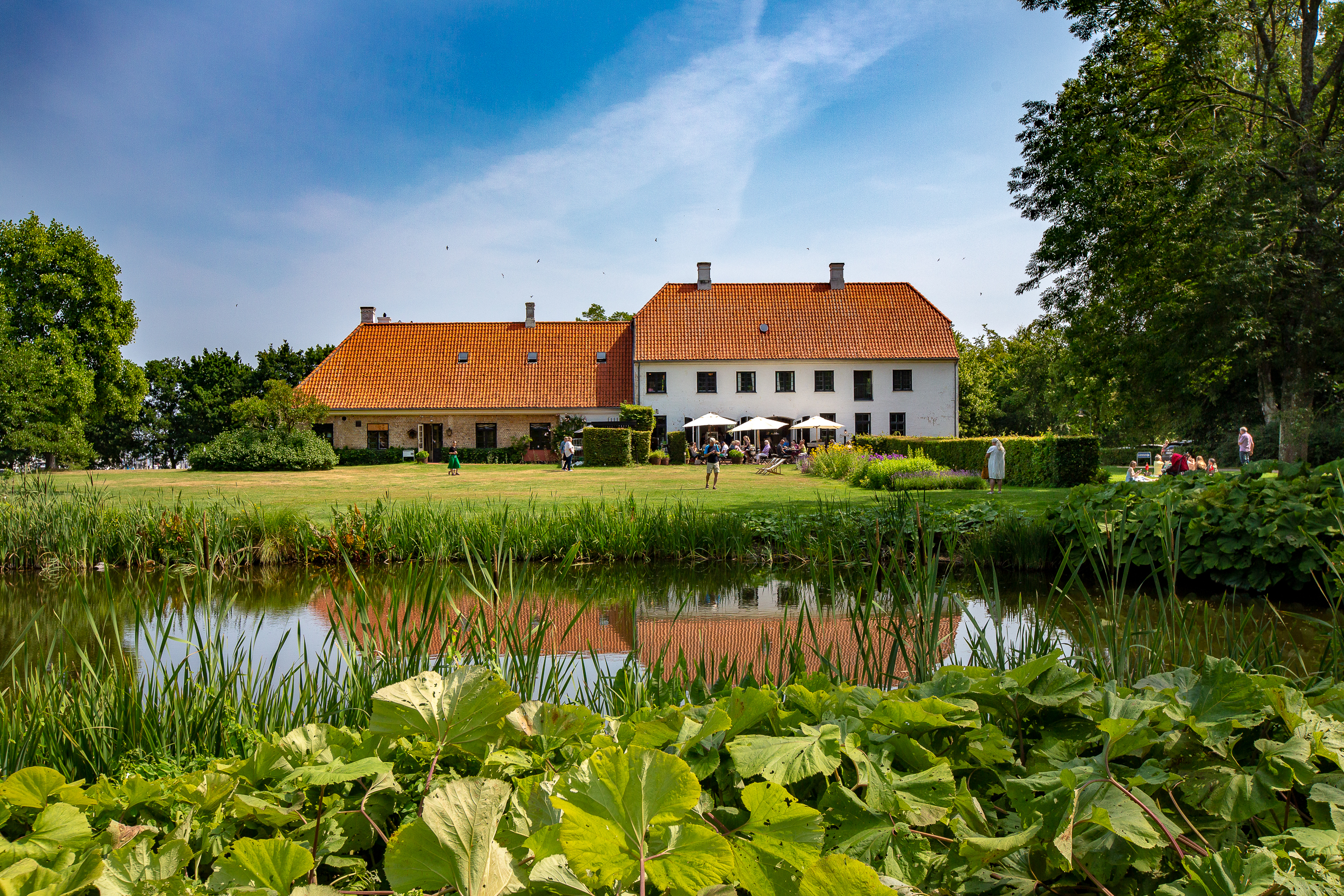 Karen Blixen’s historic house at Rungstedlund, with greenery and a pond in the foreground.