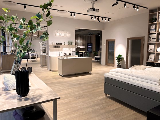 Interior of TEMPUR® Sleep Store in Carlsbergbyen, featuring ergonomic beds, pillows, and sleep consultants assisting customers.